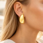 Złote kolczyki 585 pękate blaszki w uchu modelki